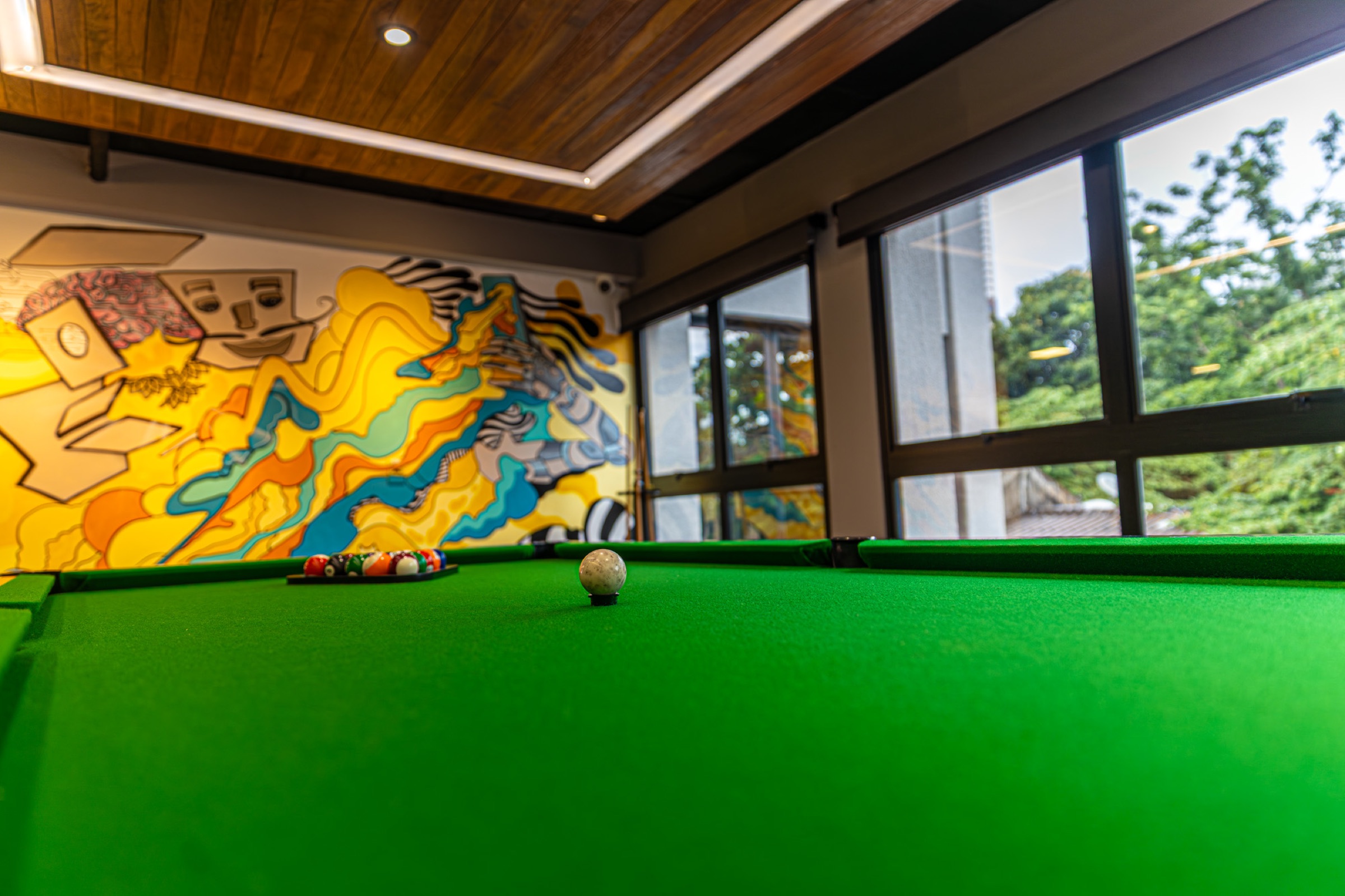 Copa Lounge do Yumit Hub — ambiente acolhedor com sofás, mesa de sinuca e iluminação suave para confraternizações e networking