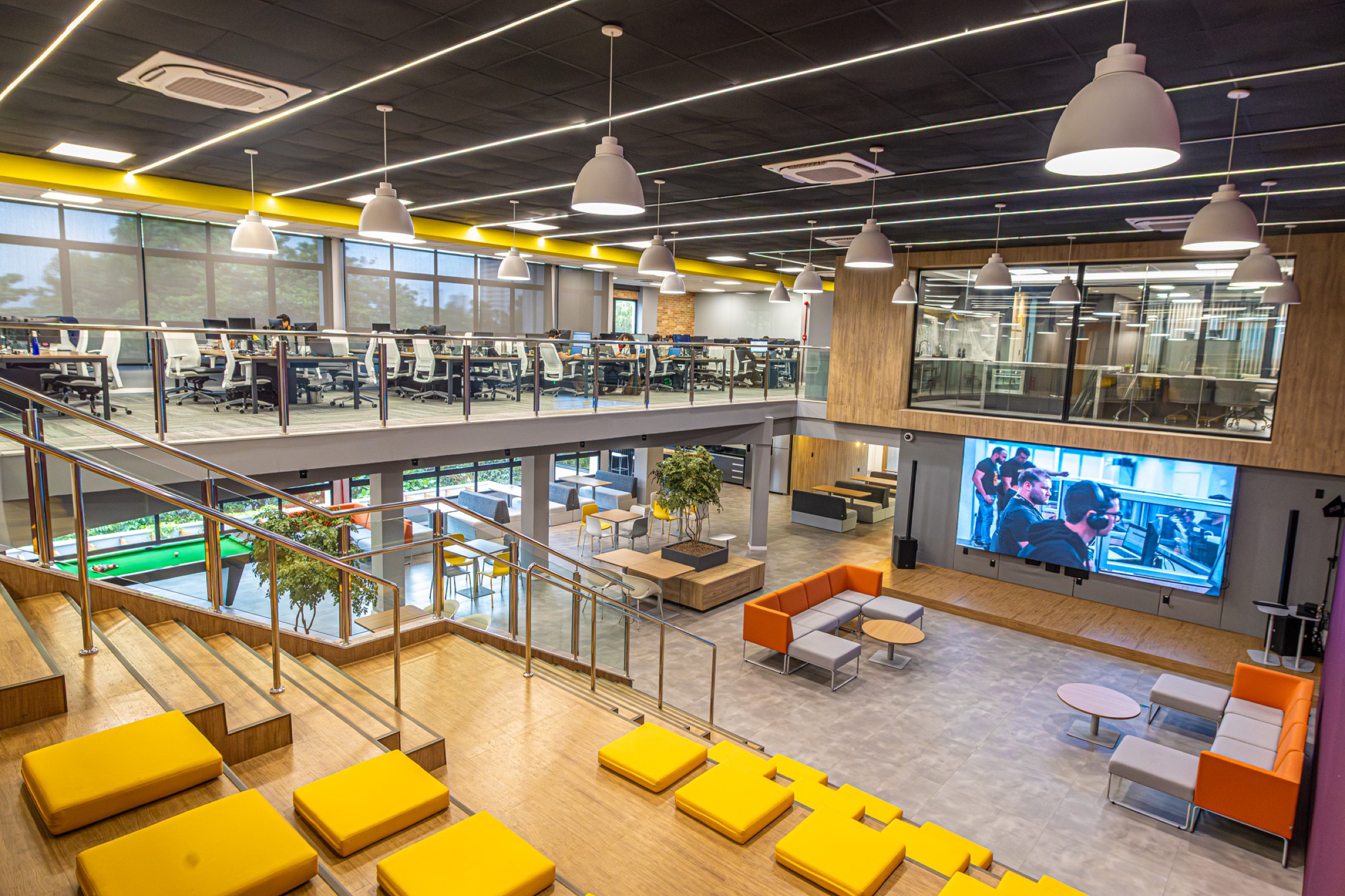 Palco Principal e Arena do Yumit Hub — auditório amplo com palco iluminado, arquibancada e telão para palestras e grandes eventos