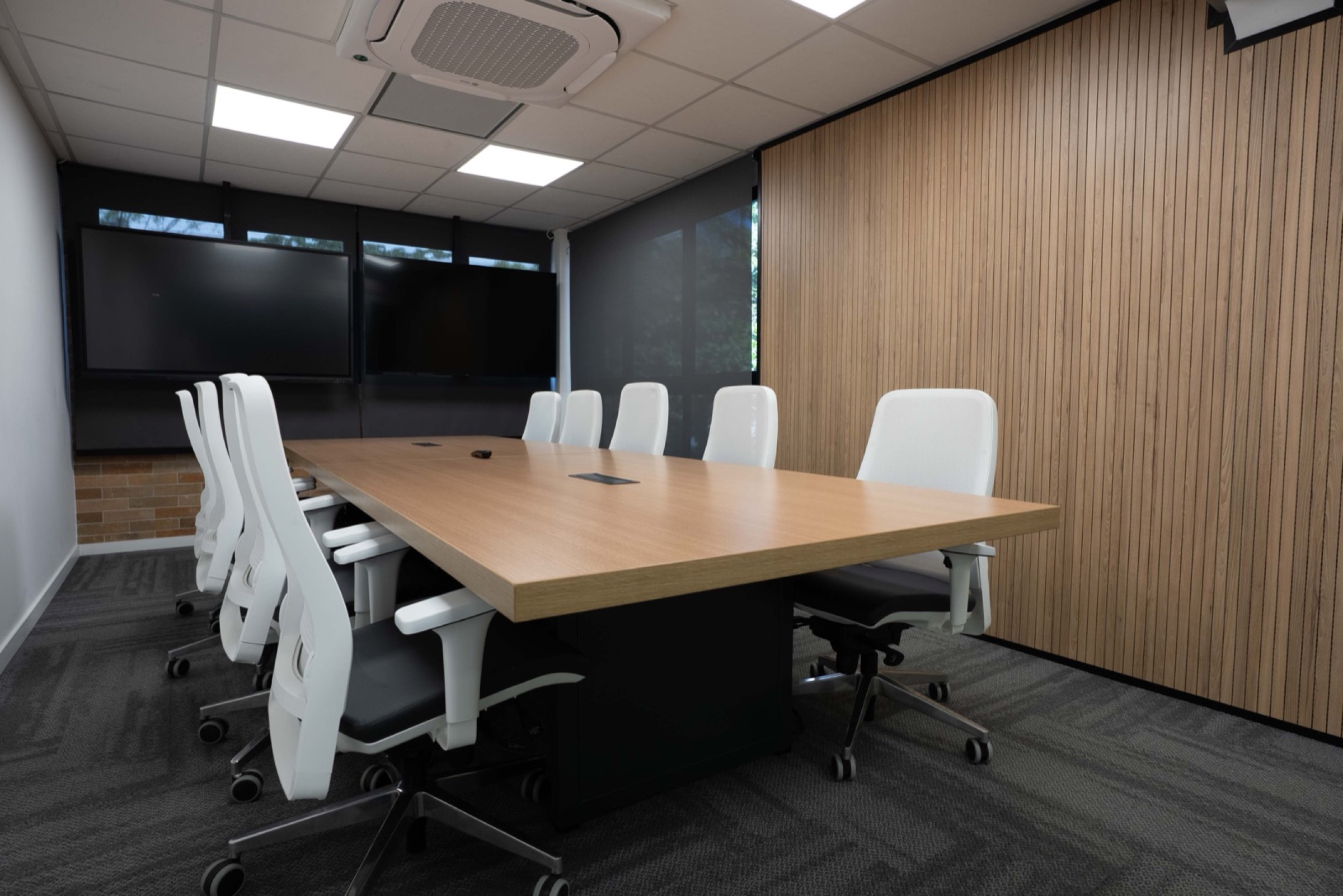 Sala de Reunião para 11 pessoas do Yumit Hub — mesa central, tela interativa e equipamento de videoconferência profissional